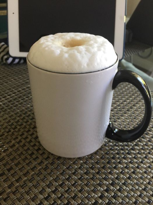 A coffee cup topped with a layer of frothy milk