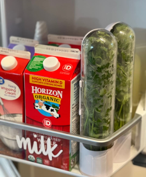 A reviewer photo showing two herb saver pods—one filled with cilantro, the other with parsley