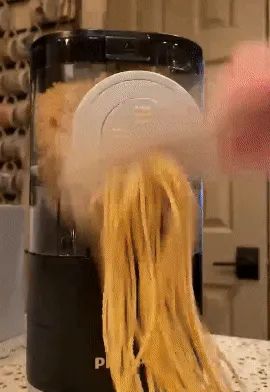 GIF of a reviewer slicing fresh pasta being extruded from the pasta maker