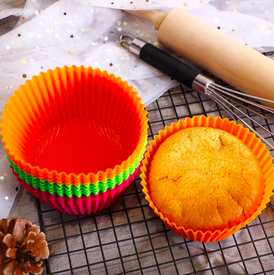A set of nesting, multi-colored muffin tins with one containing a muffin