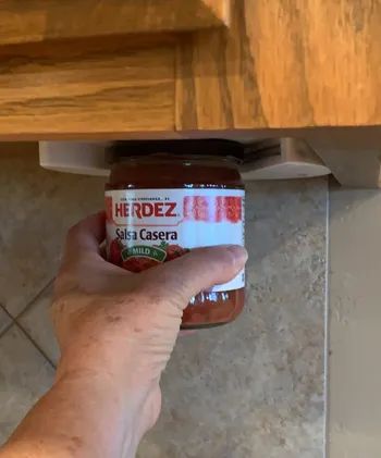 Reviewer using the jar opener to pop open a jar of salsa