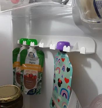 Snack pouches stored on the same organizer inside a fridge