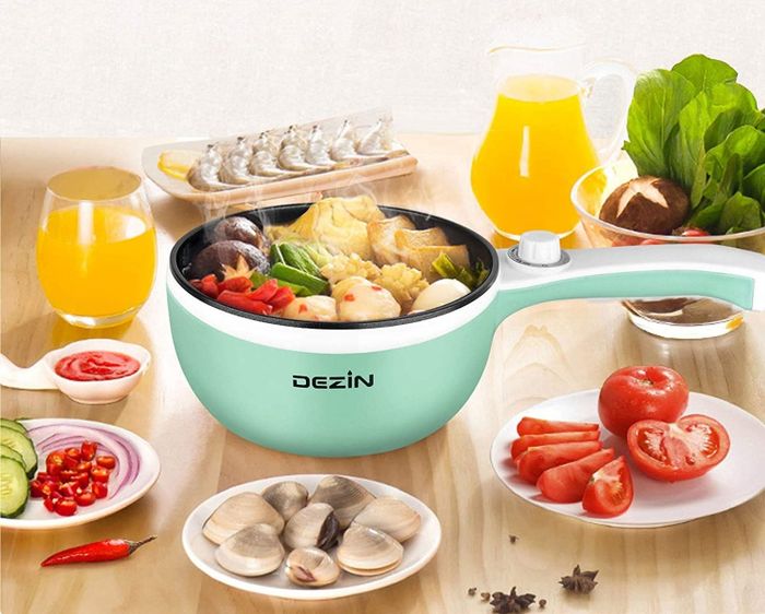Hot pot filled with various foods placed on a table surrounded by other dishes