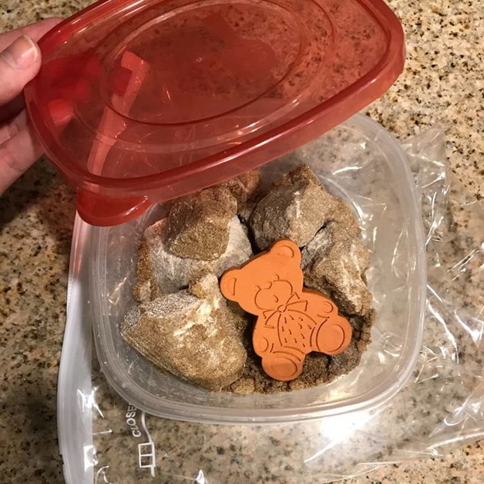 A reviewer's photo showing the sugar bear inside a container filled with hard clumps of brown sugar