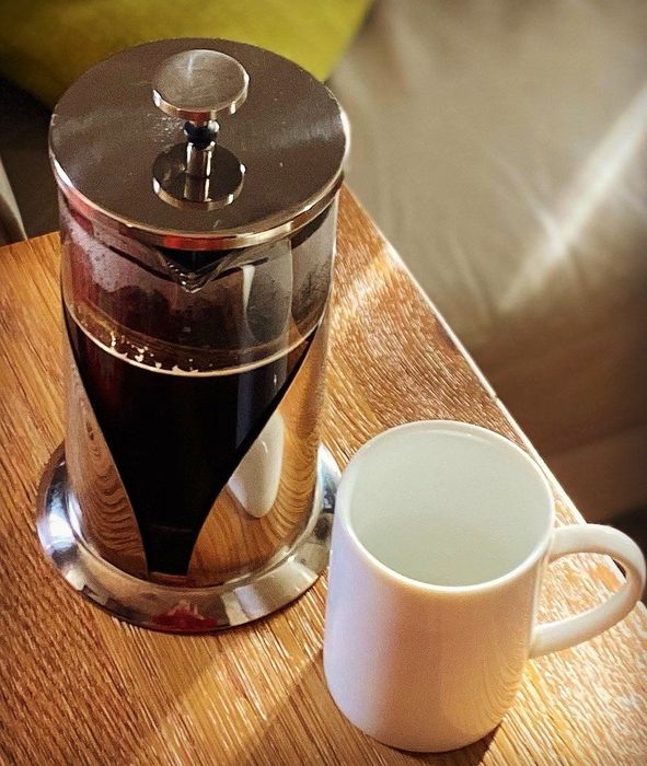 A reviewer’s photo featuring a French press next to a coffee mug