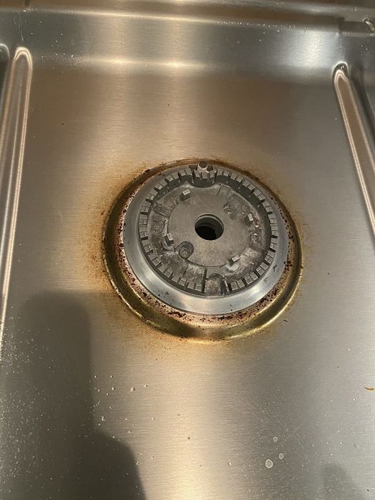A reviewer’s photo showing a dirty gas range burner