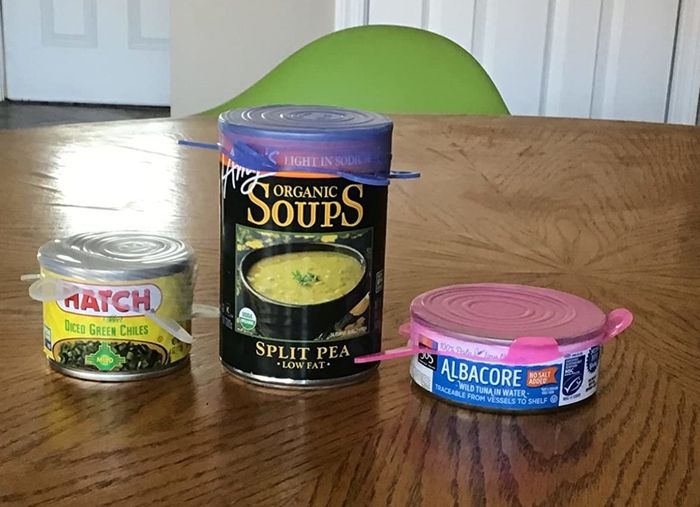 A reviewer’s photo of three cans, each topped with a silicone lid
