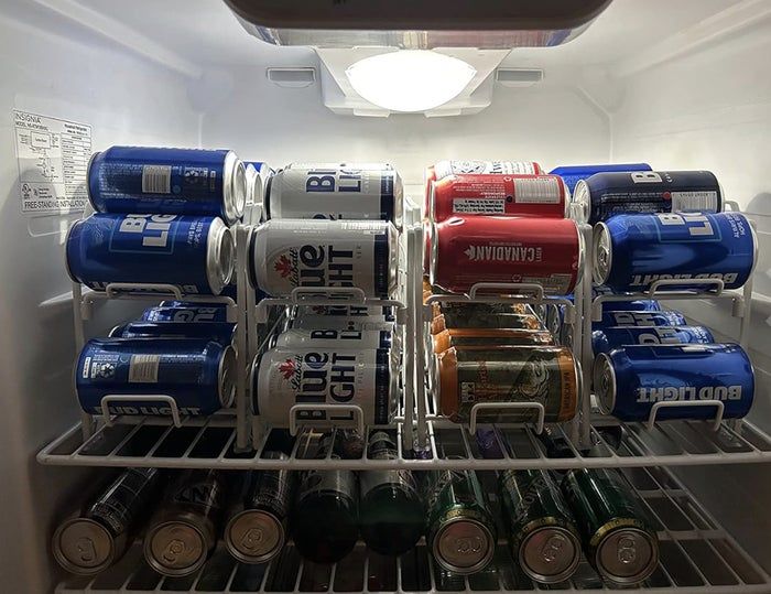 Fridge filled with various beer brands like Bud Light, Budweiser, and Michelob Ultra cans, all arranged neatly on the shelves