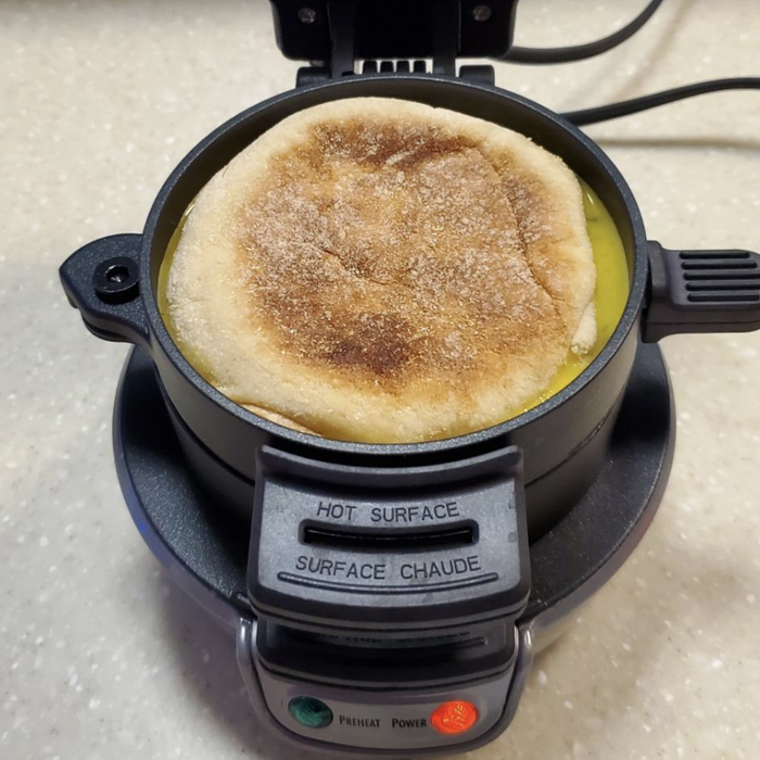 A photo from a reviewer showing an English muffin sandwich cooking in the breakfast sandwich maker.