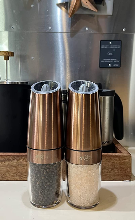 A reviewer displaying the two spice shakers side by side