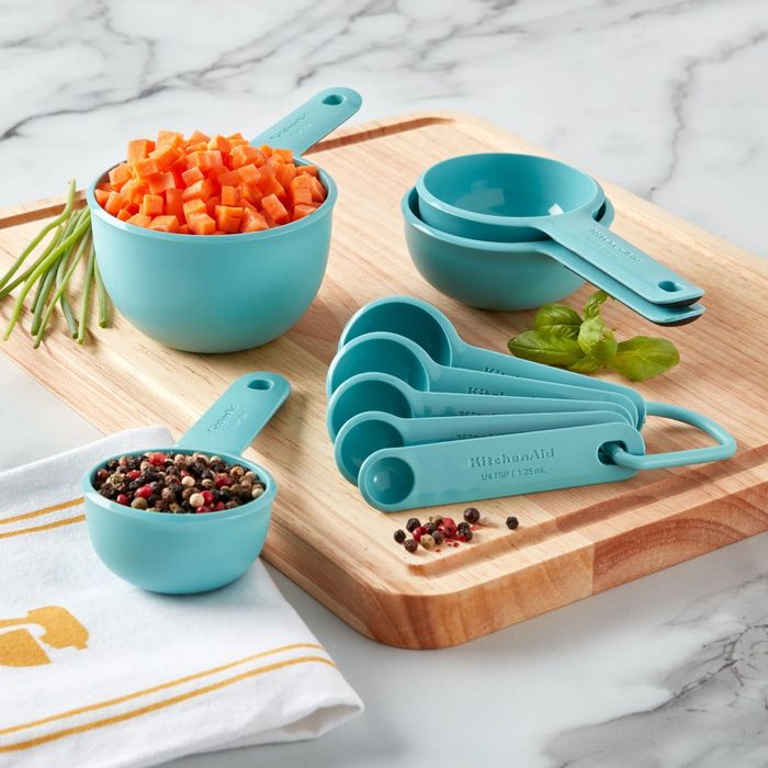 The set of measuring cups placed on a cutting board with ingredients being measured