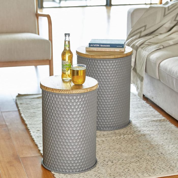 Two grey metal stools with lids featuring a smooth, natural wood top