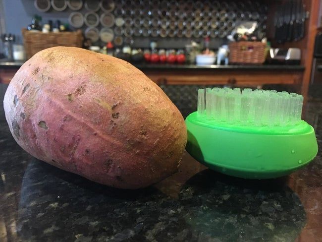 A reviewer’s image shows the scrubber placed next to a potato.