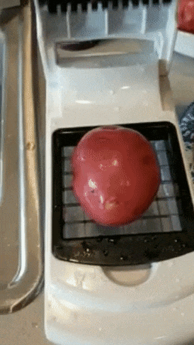 A reviewer demonstrates placing a potato onto the flip-top lid cutter and pressing the lid down to chop it into pieces.