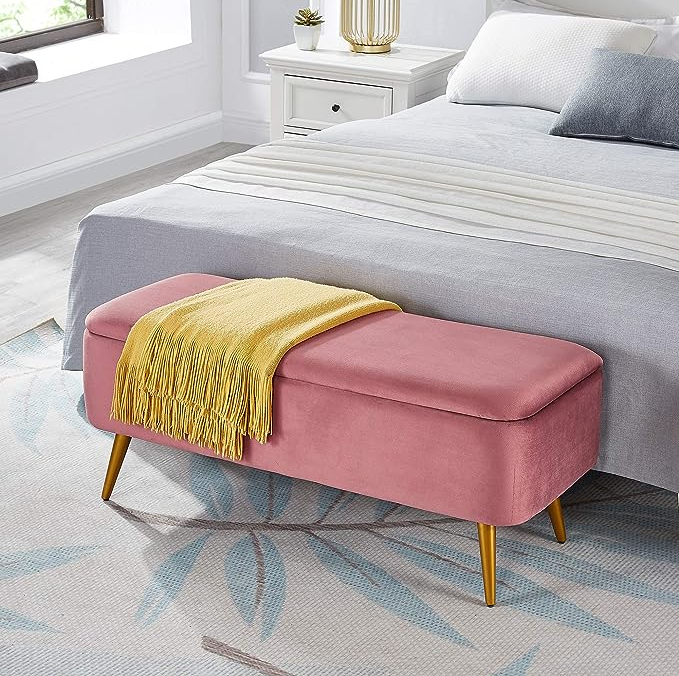 pink storage bench placed at the foot of a bed