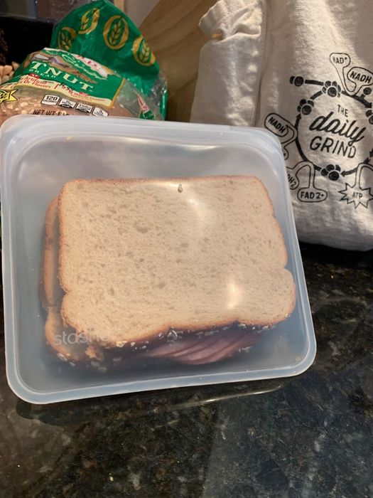 A reviewer's photo of a sandwich stored in a clear silicone bag