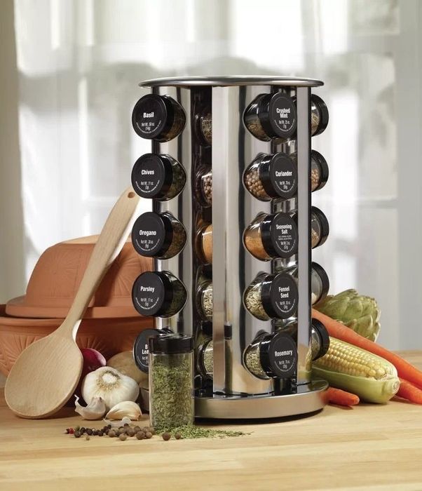 The rotating spice rack, stocked with spice jars, placed on a kitchen counter