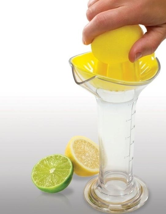 The citrus juicer with its clear container filled with fresh juice