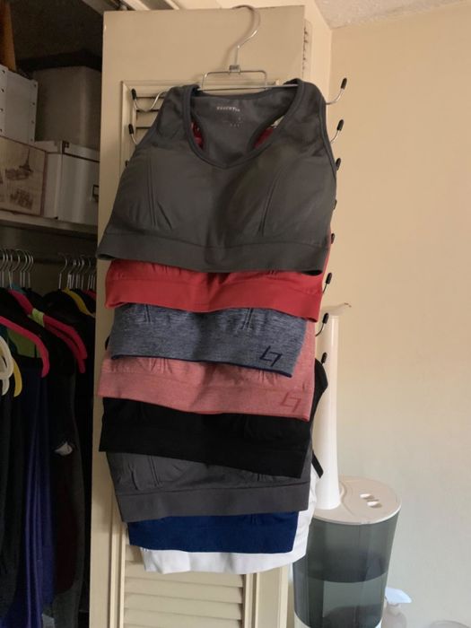 Reviewer displays the tank top and sports bra hanger