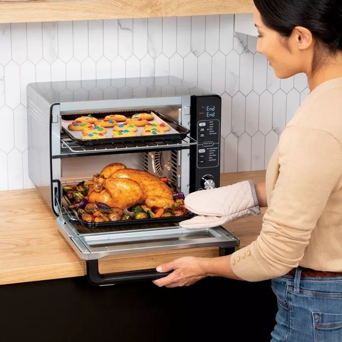 A model using the oven to cook chicken on the bottom and cookies on the top rack