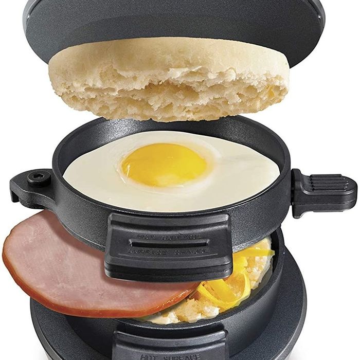 A breakfast sandwich maker filled with bread, an egg, ham, and melted cheese, preparing a delicious sandwich.