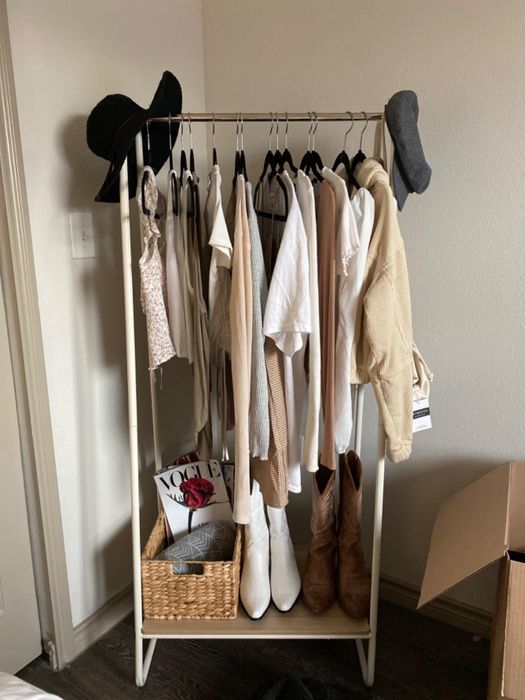 reviewer's garment rack with clothes hanging and boots stored on the bottom shelf
