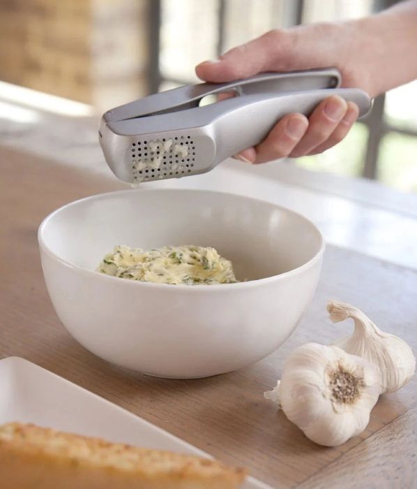 The garlic press crushing garlic cloves effortlessly
