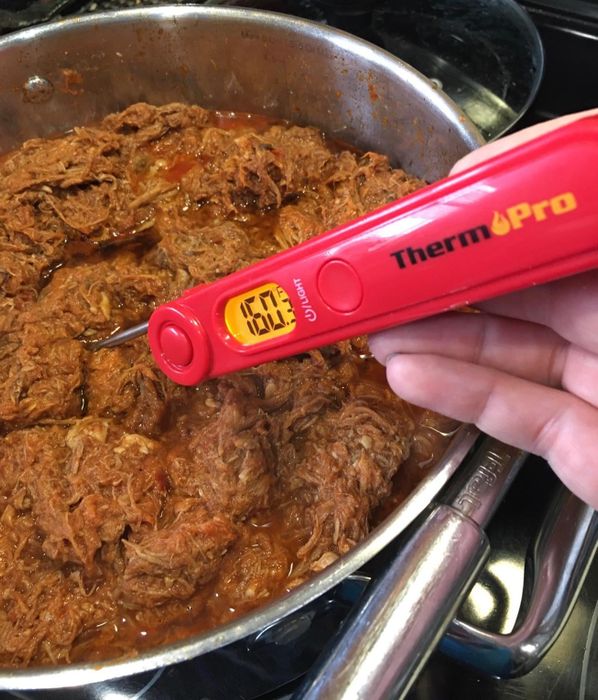 A reviewer’s photo showing the food thermometer being used to check the temperature of food in a pan.