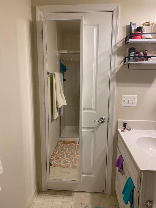 The same reviewer's cabinet in its closed state, appearing as a simple mirror on the back of the door.