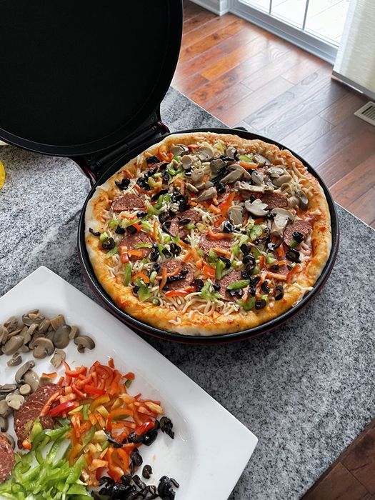 An open pizza maker with a pizza inside
