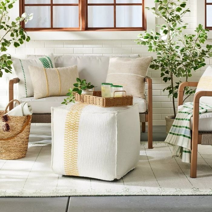 A cozy home interior with a sofa, plants, and wicker accents, showcasing a natural decor style and offering shopping inspiration