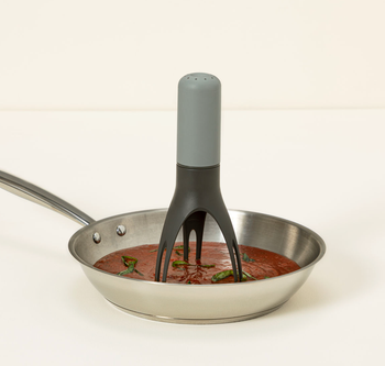 The three-pronged automatic stirrer inside a pan.