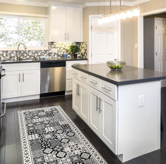 A gray vinyl mat with a printed tile design laid out on a kitchen floor