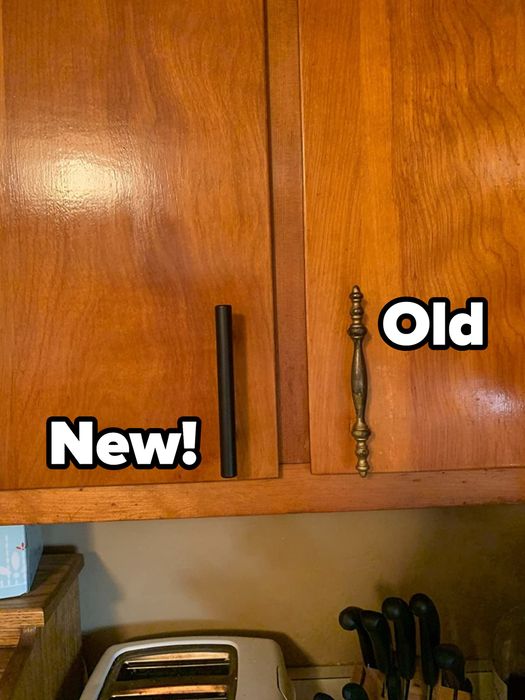 A reviewer's kitchen cabinet showcasing the black cabinet pull next to an old cabinet pull