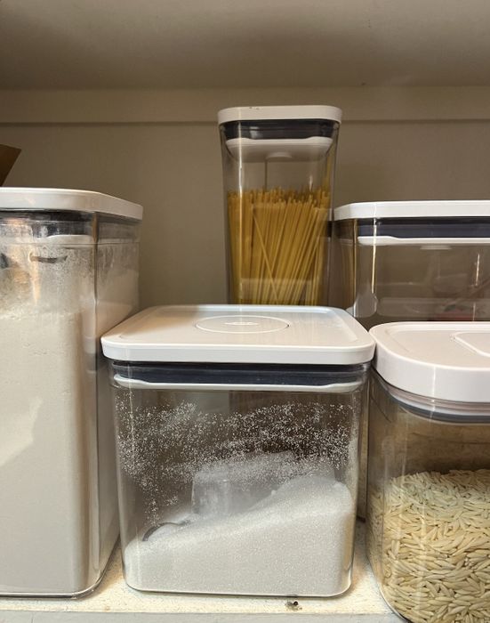 A set of five containers in various sizes, each holding pantry staples.