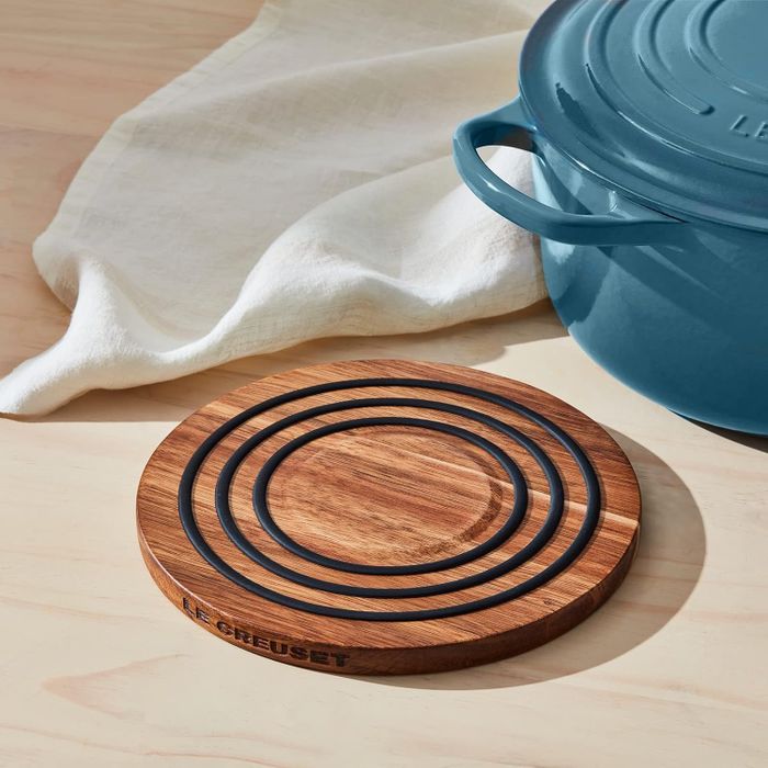 An acacia wood trivet featuring magnetic rings for added stability