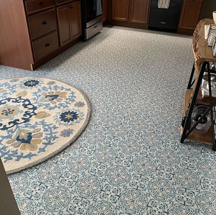 A reviewer photo of the same kitchen now with the blue adhesive tiles applied to the floor