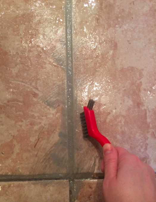 A customer review photo showing the process of scrubbing the grout to remove stains
