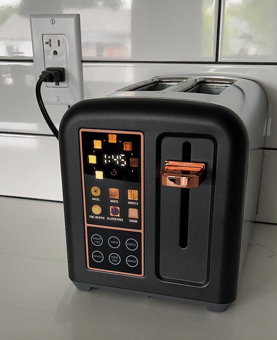 A sleek black toaster with a touch screen interface on the kitchen counter