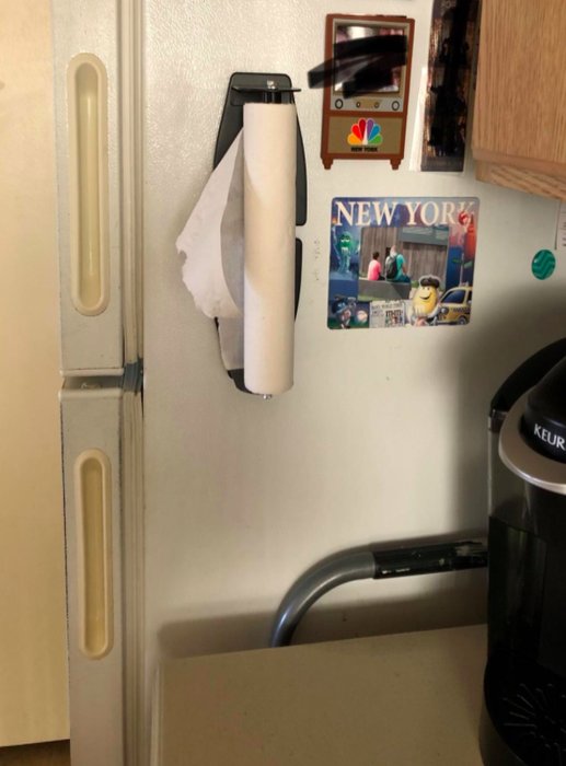 The paper towel holder mounted on the fridge