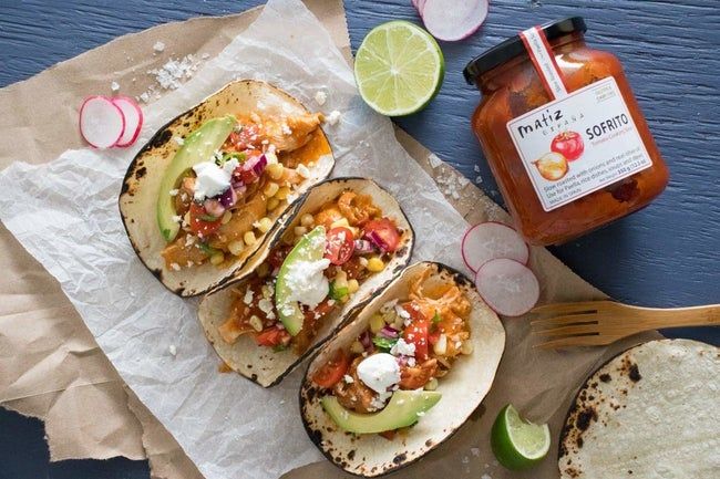 A jar of Matiz Sofrito placed next to some tacos, ready to enhance the meal.