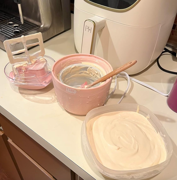 A small pink ice cream maker sitting on the kitchen counter, ready for use.