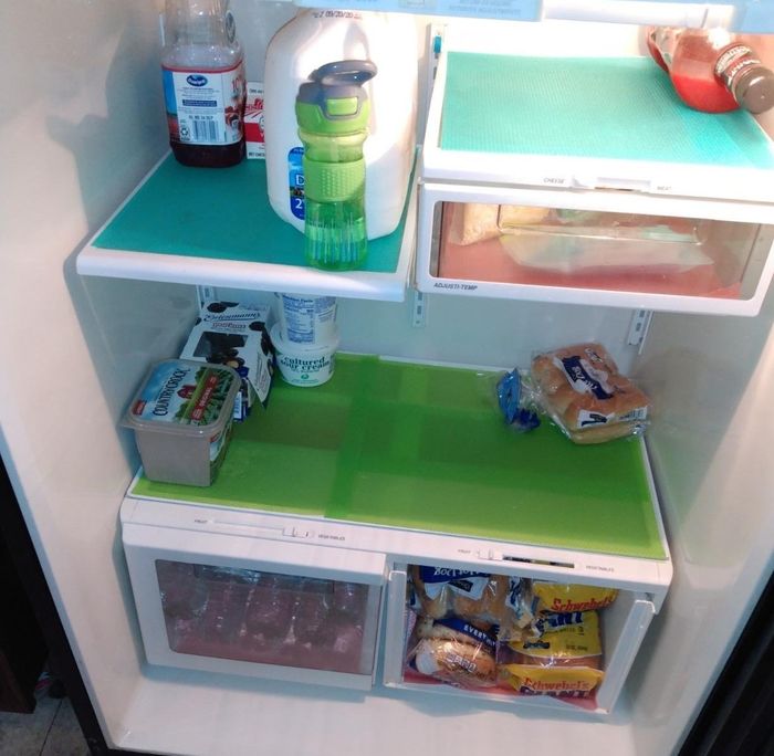 Fridge mats placed neatly in an open fridge, helping to keep it organized.