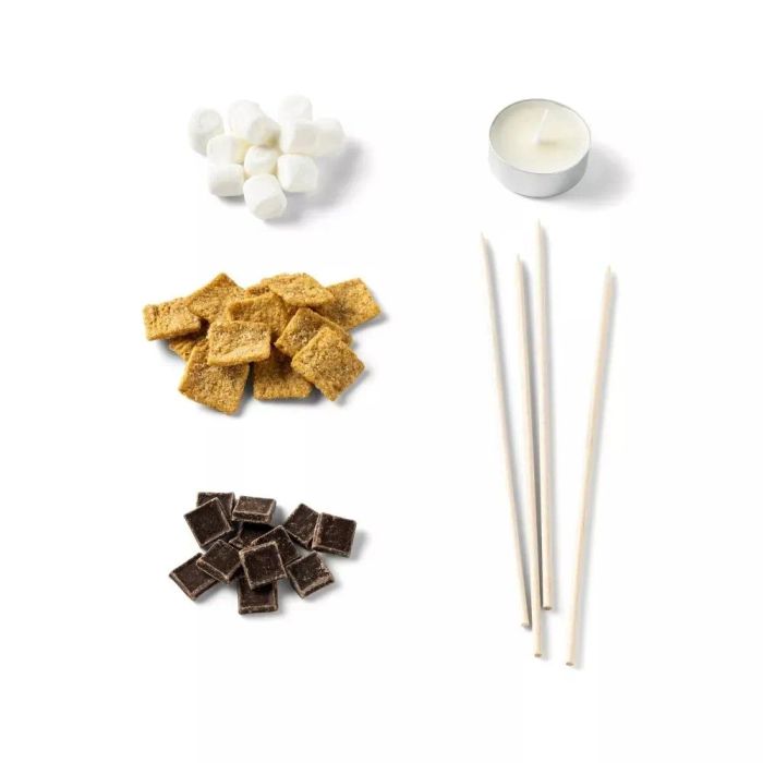 Marshmallows, graham cracker cereal squares, chocolate pieces, a tealight candle, and four long wooden skewers. Perfect for crafting mini s'mores