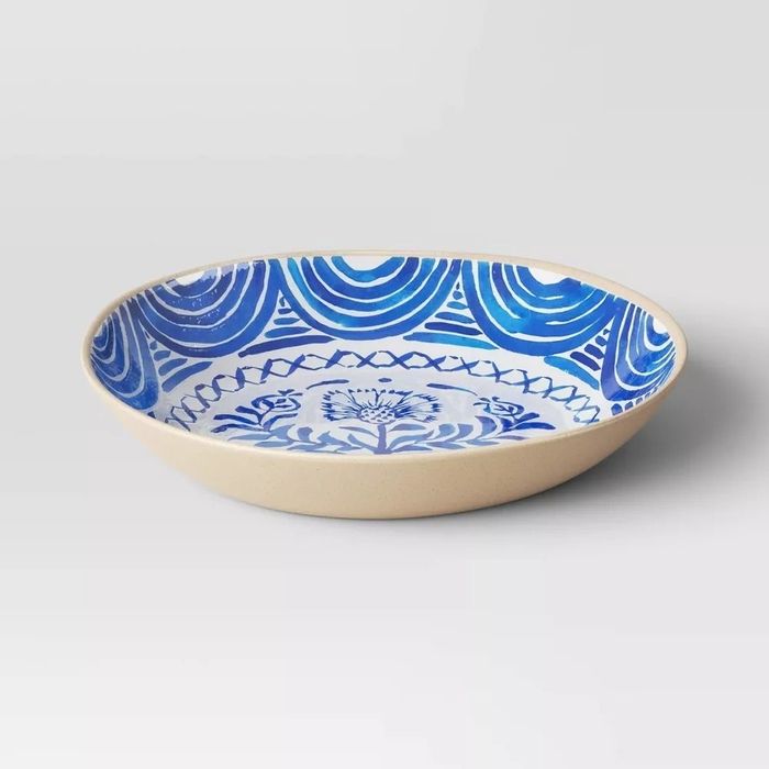 A ceramic serving bowl adorned with intricate blue patterns and a floral design, perfect for any shopping list or article.