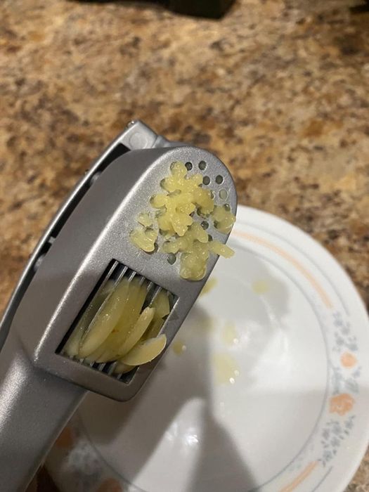 A reviewer photo showing the press slicing and mincing garlic