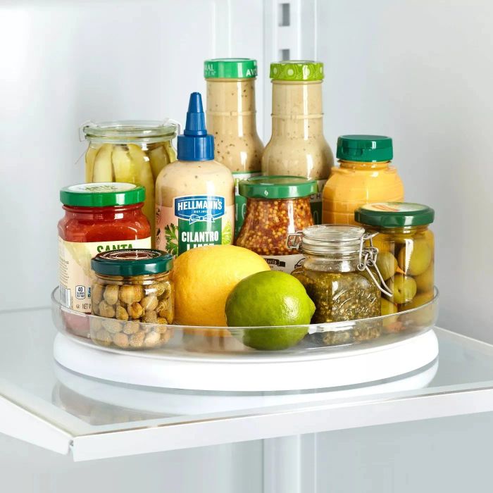 A refrigerator turntable holding various condiments on a refrigerator shelf.