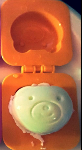 An egg mold with a bear face imprint