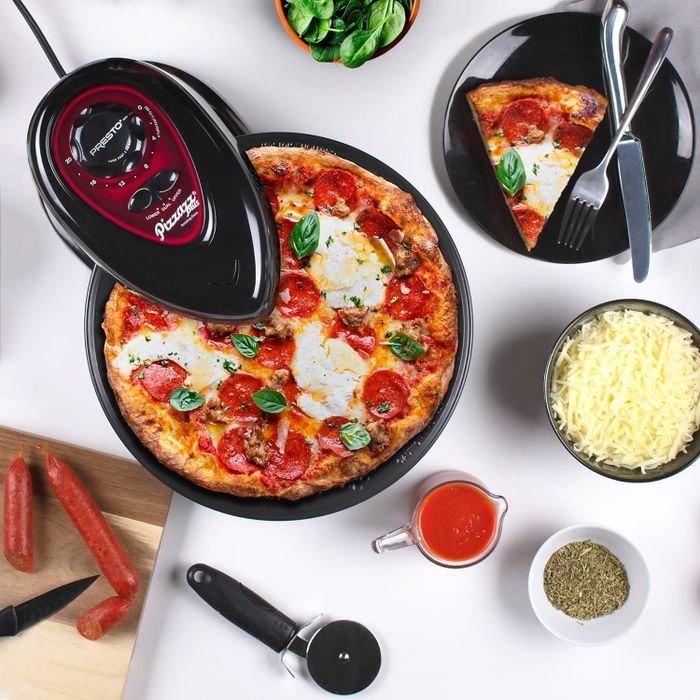 a rotating pizza oven preparing a pepperoni and mozzarella pizza