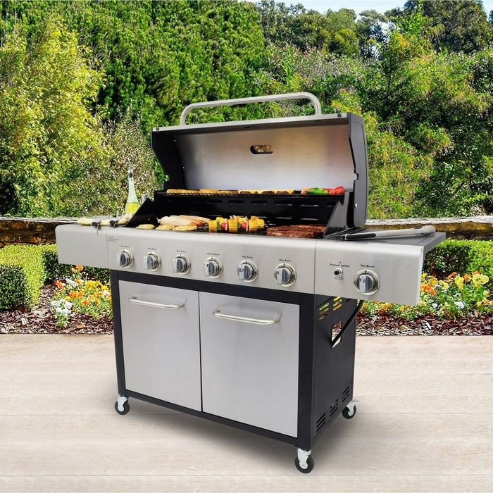 A stainless steel outdoor grill cooking food, set against a patio backdrop, ideal for family barbecues